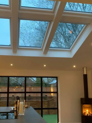 kitchen showing grid windows and skylights with a wood burner in the corner